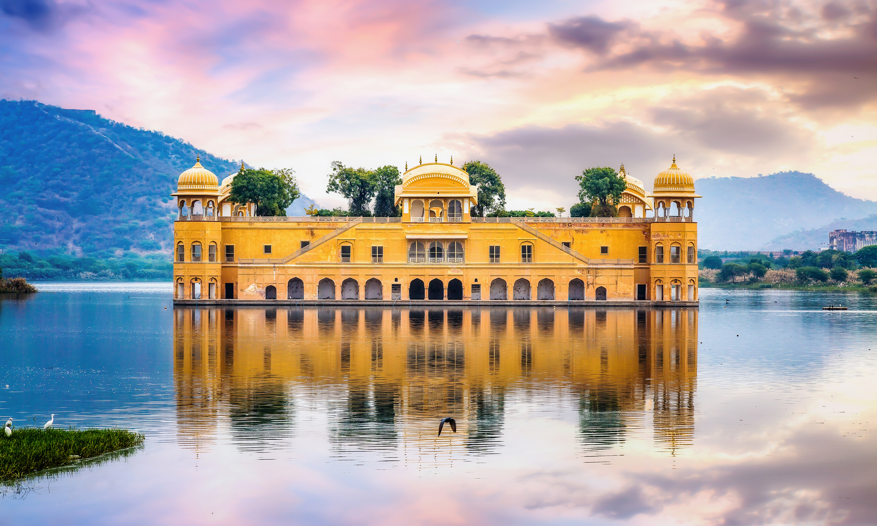 Jal Mahal water palace Jaipur Rajasthan with landscape at sunset.